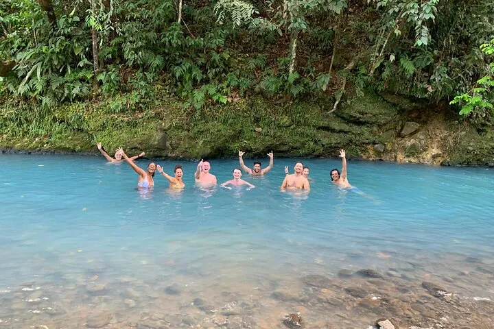 Hikers crossing a rainforest footbridge in Tenorio Volcano National Park on the Rio Celeste Blue River Adventure hike, Costa Rica