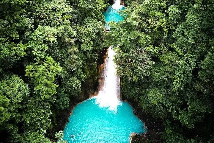 Llanos de Cortés waterfall with a sandy swimming bank on the Rio Celeste, sloth sanctuary and waterfall tour from Guanacaste, Costa Rica